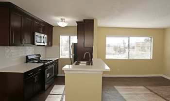 A kitchen with a white countertop and brown cabinets.